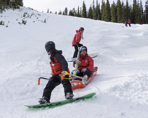 ski patrol bringing down sled